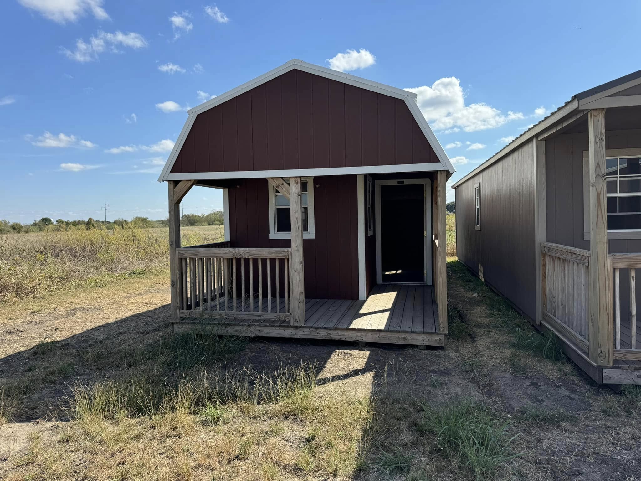 Red lofted cabin with a covered front porch